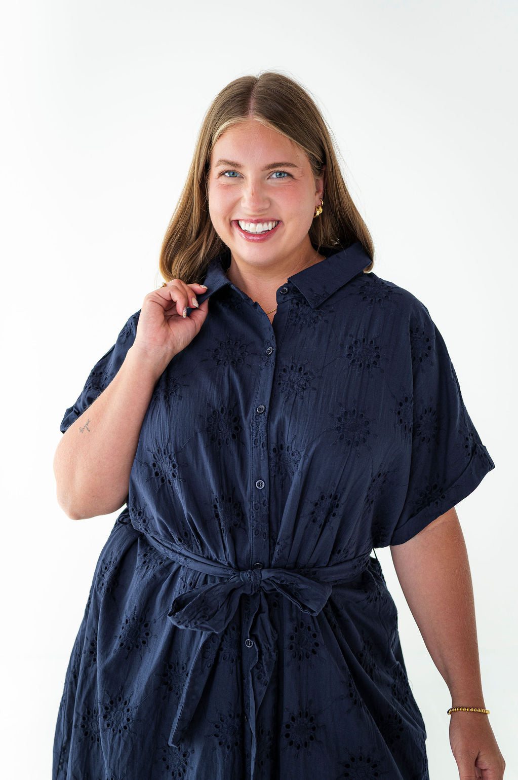 Woman wearing a navy blue dress with a white background