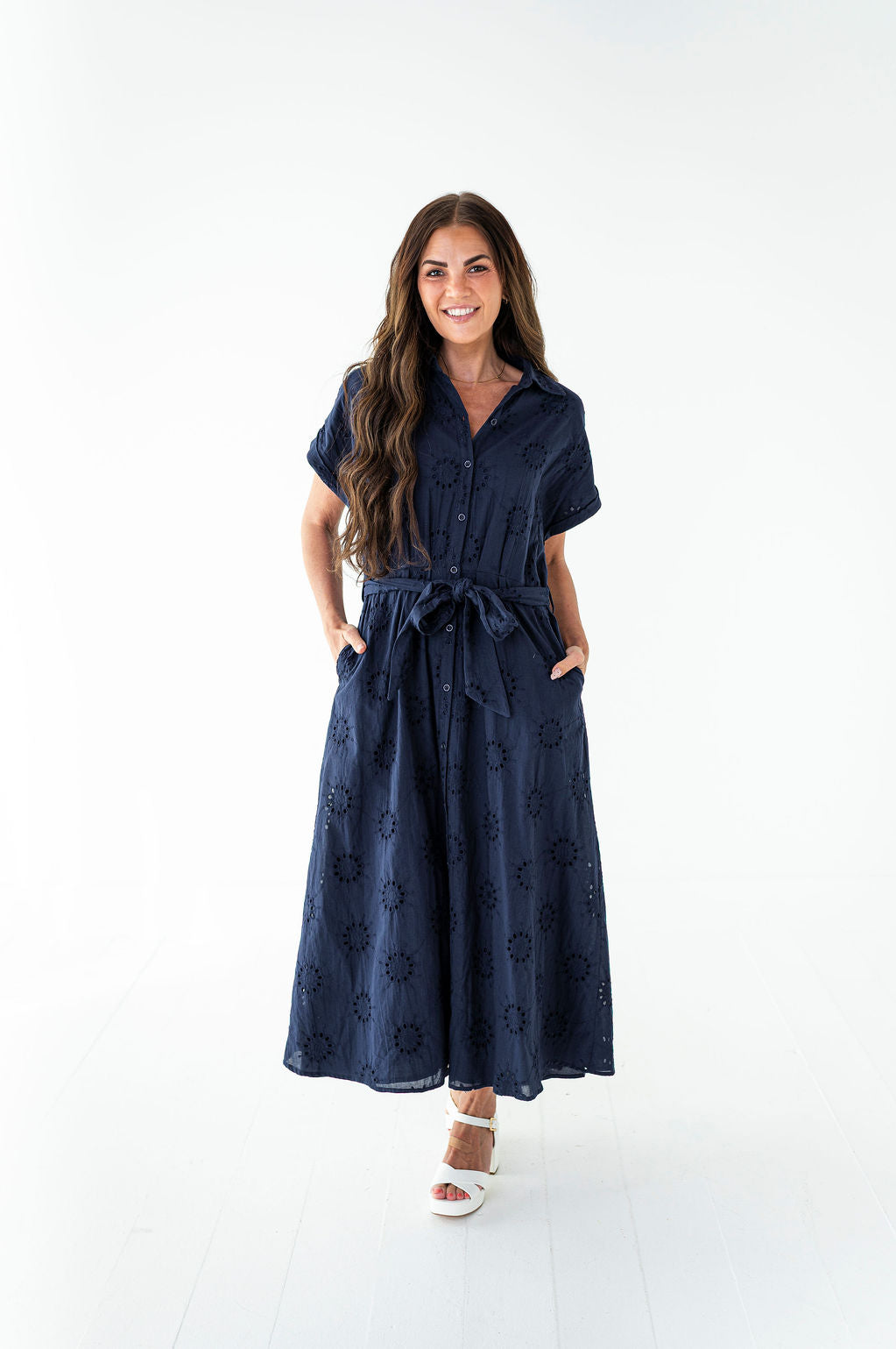 Woman wearing a navy blue dress with a white background