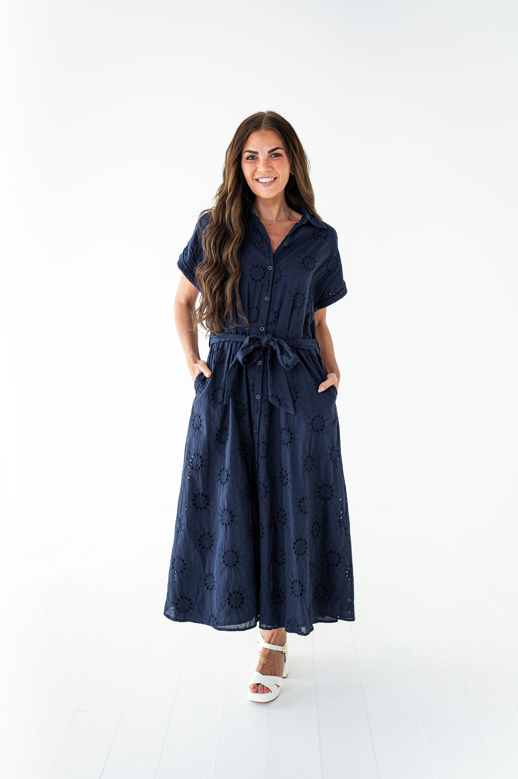 Woman wearing a navy blue dress with a white background