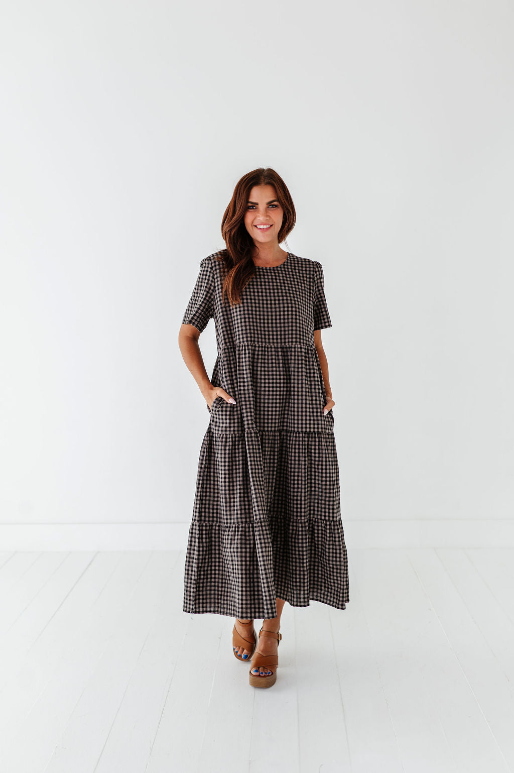 Woman wearing a checkered dress on a white background