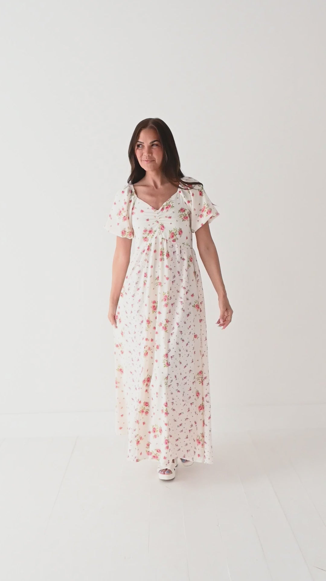Video of a woman wearing a floral dress on a white background